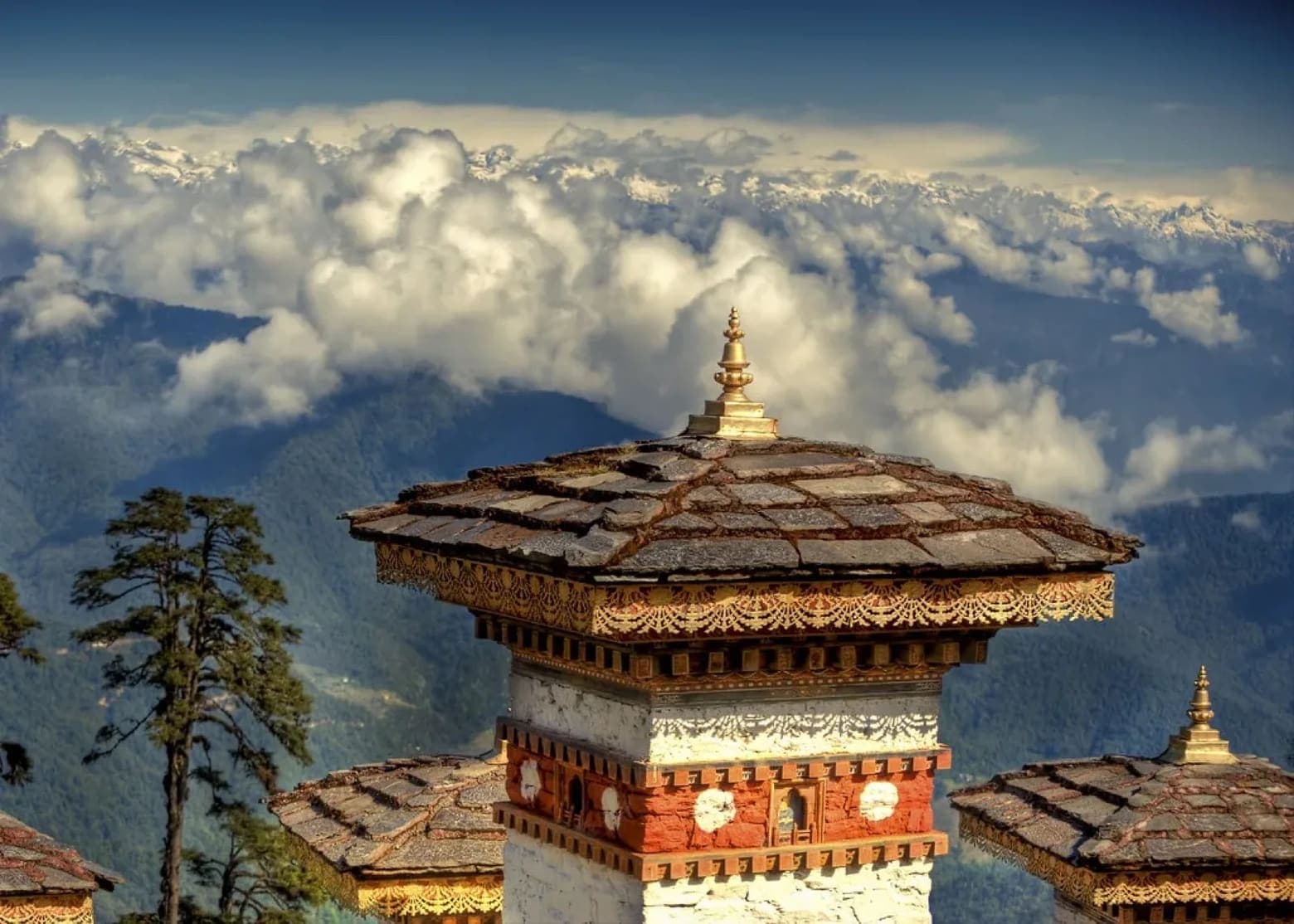 A dzong-style tower rising above a sea of clouds